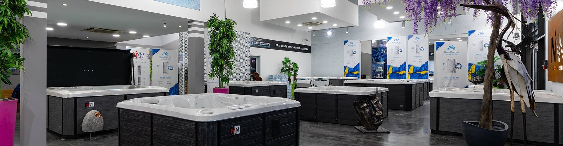 Showroom du Groupe L'Espadon, une dizaine de spas alignés sous les enseignes des gammes, vue panoramique